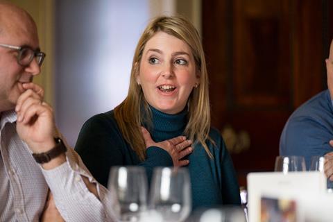 Photograph focused on RGI Solutions director Sarah Glenn talking at the roundtable with her hand to her heart.